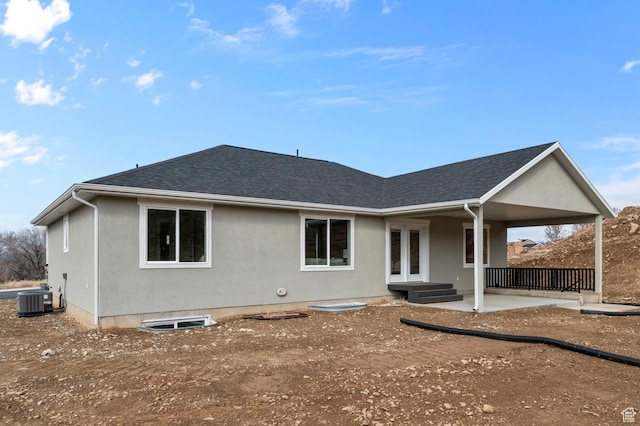 rear view of house featuring french doors, a shingled roof, and central AC unit