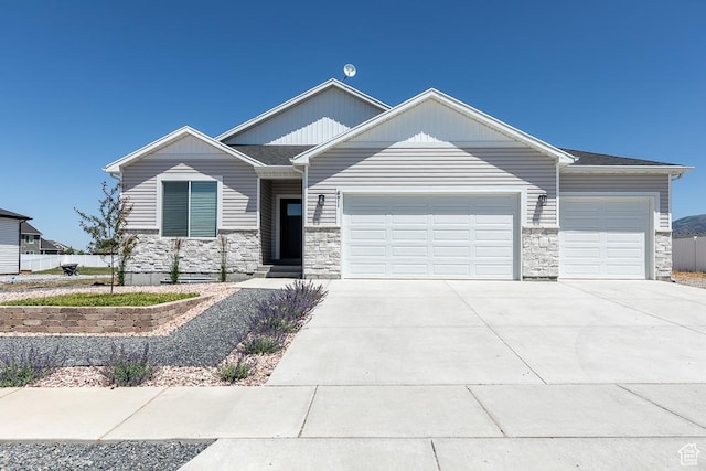 471 E 600 S, Hyrum, UT 84319 - craftsman house featuring an attached garage, stone siding, and concrete driveway
