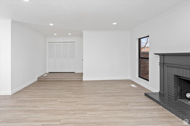 unfurnished living room with baseboards, a fireplace, ornamental molding, and light wood finished floors