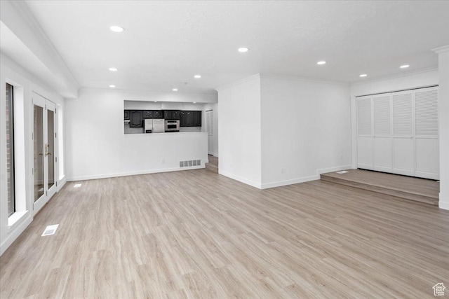 unfurnished living room with ornamental molding, baseboards, light wood-style floors, and visible vents