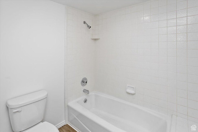 bathroom with toilet, shower / bath combination, baseboards, and wood finished floors
