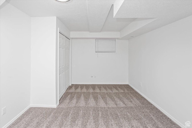 empty room with baseboards, carpet flooring, and a textured ceiling