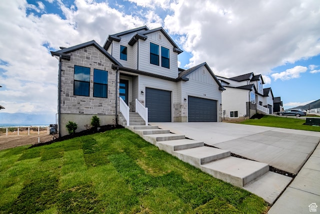 1258 S Boxelder Dr, Saratoga Springs, UT 84005 - view of front facade with board and batten siding, stone siding, driveway, a front yard, and an attached garage