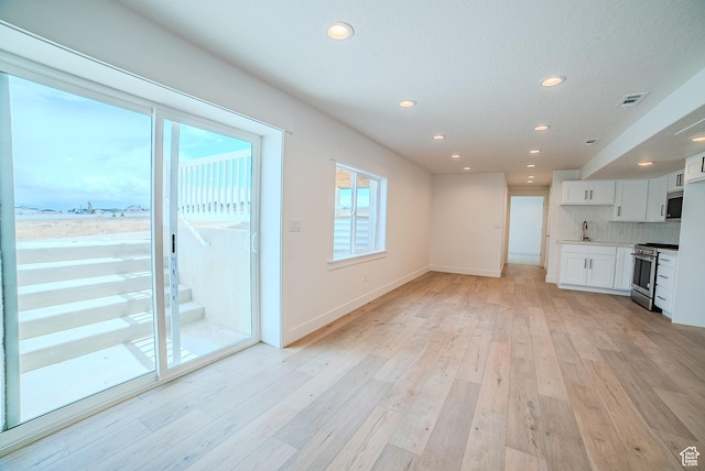 1258 S Boxelder Dr, Saratoga Springs, UT 84005 - unfurnished living room featuring a sink, recessed lighting, light wood finished floors, and baseboards