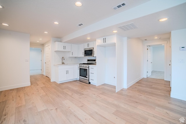 1258 S Boxelder Dr, Saratoga Springs, UT 84005 - kitchen featuring gas stove, stainless steel microwave, a sink, white cabinetry, and light wood-style flooring