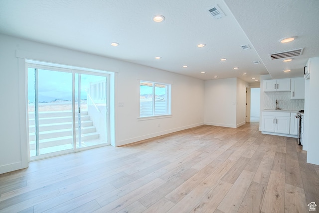 1258 S Boxelder Dr, Saratoga Springs, UT 84005 - unfurnished living room featuring recessed lighting, baseboards, and light wood-style flooring