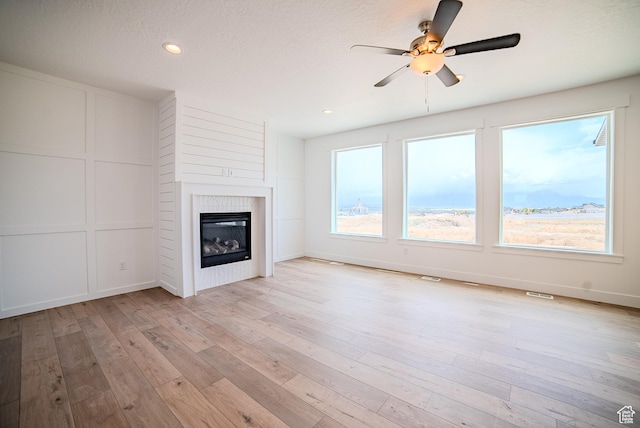 1258 S Boxelder Dr, Saratoga Springs, UT 84005 - unfurnished living room featuring a ceiling fan, light wood finished floors, a glass covered fireplace, recessed lighting, and baseboards
