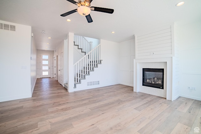 1258 S Boxelder Dr, Saratoga Springs, UT 84005 - unfurnished living room featuring light wood finished floors, a glass covered fireplace, stairs, ceiling fan, and recessed lighting