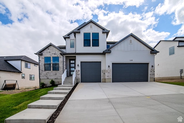 1258 S Boxelder Dr, Saratoga Springs, UT 84005 - view of front facade featuring board and batten siding, concrete driveway, stone siding, a garage, and a front yard