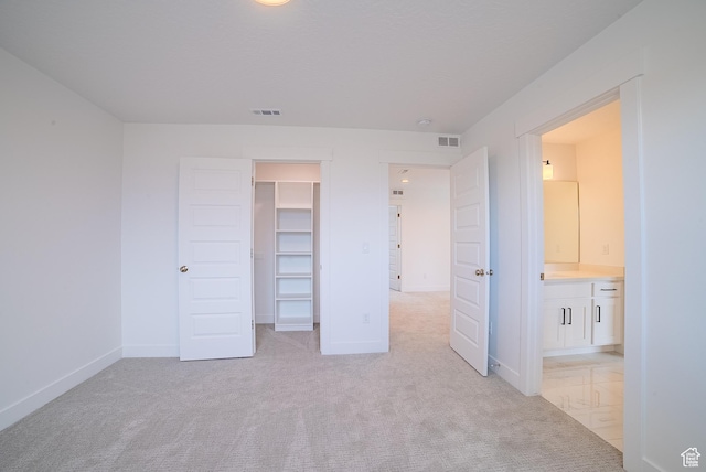 1258 S Boxelder Dr, Saratoga Springs, UT 84005 - unfurnished bedroom with a spacious closet, light carpet, baseboards, ensuite bathroom, and a closet