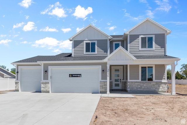 view of front of property featuring stone siding, board and batten siding, and concrete driveway