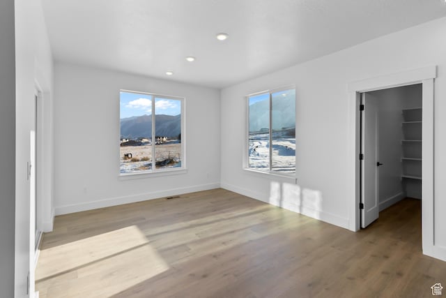 2961 N 2350 W Unit 107, Farr West, UT 84404 - unfurnished bedroom with wood finished floors, a spacious closet, a mountain view, baseboards, and recessed lighting