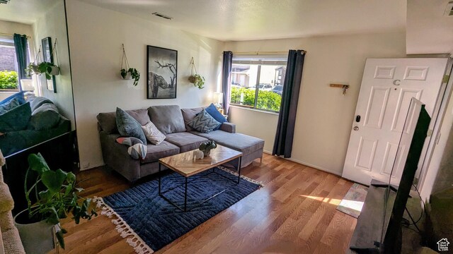 living area featuring a wealth of natural light, wood finished floors, and visible vents