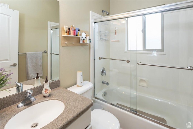 full bath featuring toilet, shower / bath combination with glass door, and vanity
