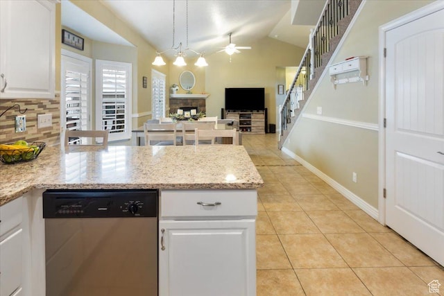 kitchen with light tile patterned flooring, a ceiling fan, a fireplace, white cabinetry, and stainless steel dishwasher