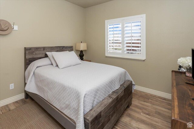 bedroom with baseboards and wood finished floors