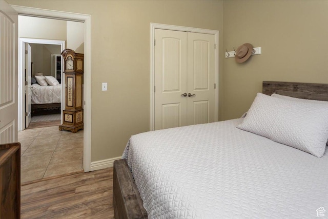 bedroom featuring baseboards, a closet, and wood finished floors