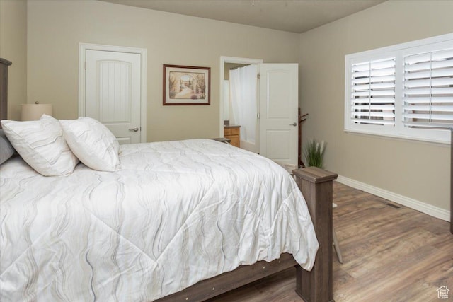 bedroom featuring baseboards and wood finished floors
