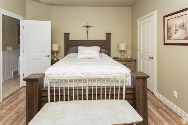 bedroom featuring baseboards, visible vents, and wood finished floors