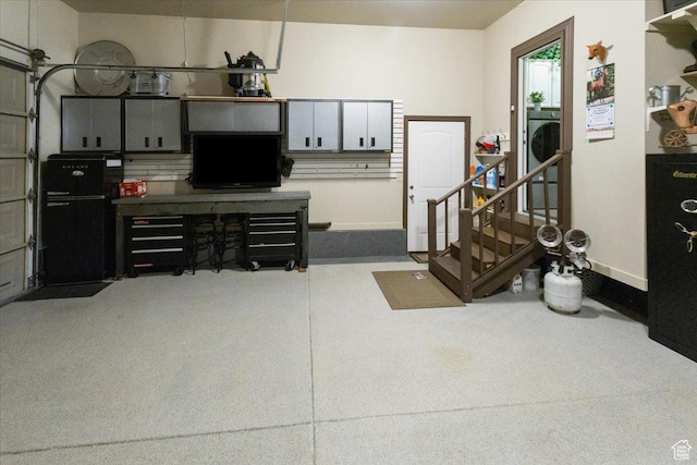 garage featuring baseboards and washer / dryer