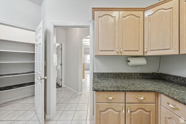 3546 Windmill Dr, Santa Clara, UT 84765 - kitchen with light tile patterned floors, baseboards, dark stone counters, and light brown cabinetry