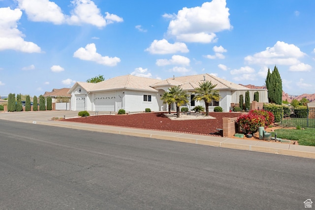 3546 Windmill Dr, Santa Clara, UT 84765 - view of front facade featuring stucco siding, an attached garage, fence, and concrete driveway