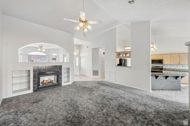3546 Windmill Dr, Santa Clara, UT 84765 - unfurnished living room featuring a tiled fireplace, built in shelves, light carpet, visible vents, and ceiling fan