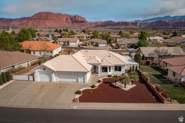 view of front of house featuring a residential view, a garage, and a mountain view