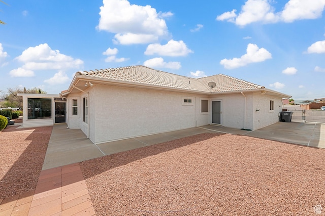 3546 Windmill Dr, Santa Clara, UT 84765 - back of property featuring a sunroom, fence, a patio, a tile roof, and stucco siding