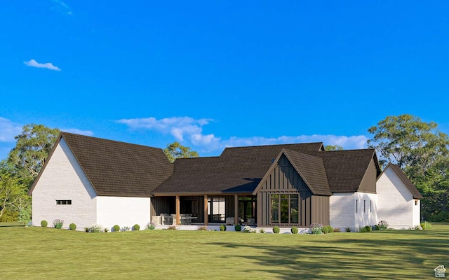 rear view of property with a sunroom, board and batten siding, and a yard
