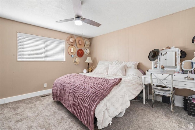 carpeted bedroom with baseboards, a textured ceiling, visible vents, and a ceiling fan