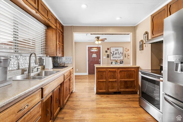 kitchen featuring light wood-style flooring, a sink, stainless steel appliances, and brown cabinets