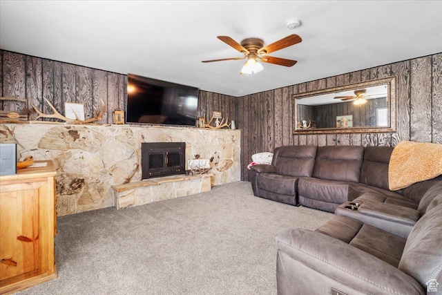 living room featuring a fireplace, carpet flooring, ceiling fan, and wooden walls