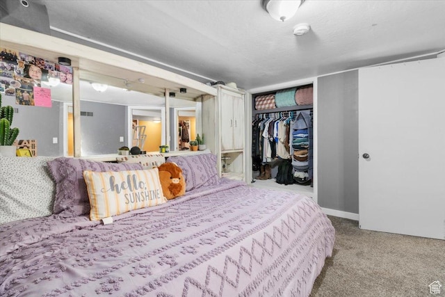 carpeted bedroom featuring baseboards and a closet