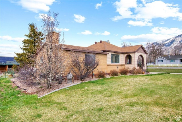 ranch-style house with a front lawn, a chimney, and brick siding