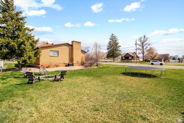 view of yard with central AC and a trampoline