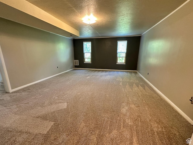 empty room featuring a textured ceiling, baseboards, and carpet floors