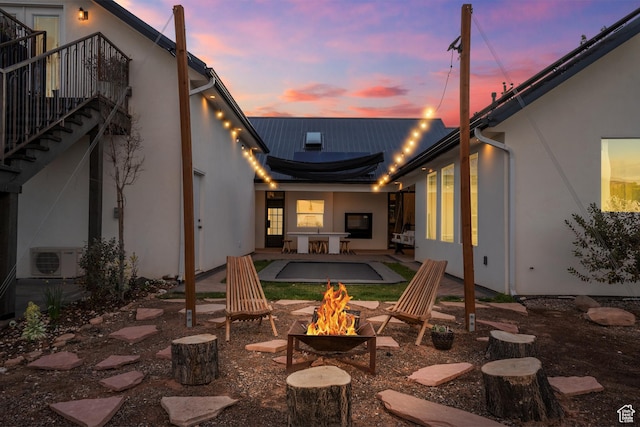 view of patio featuring ac unit, a fire pit, and stairs
