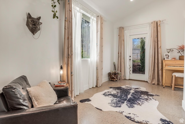 sitting room with speckled floor and vaulted ceiling