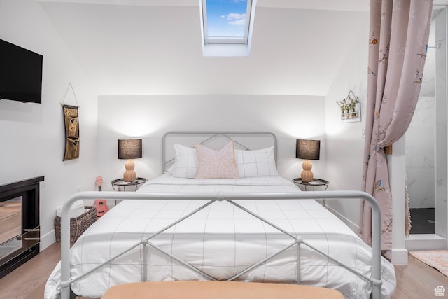 bedroom featuring a skylight and wood finished floors