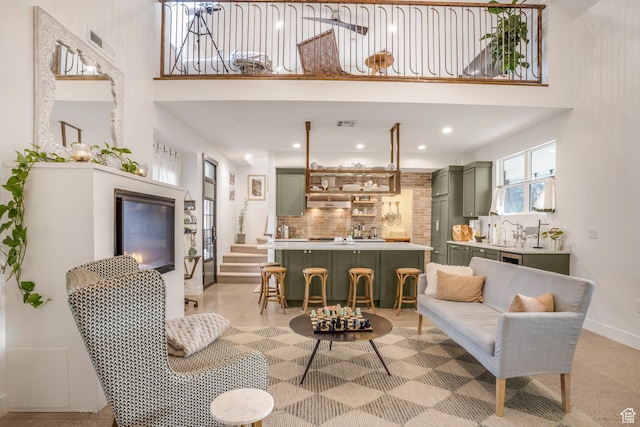 living room with a high ceiling, baseboards, visible vents, and recessed lighting