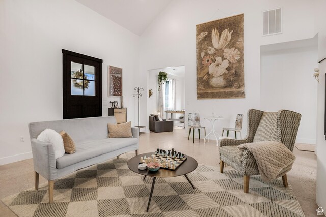 living room featuring high vaulted ceiling, visible vents, and baseboards