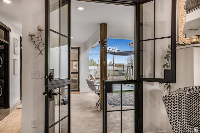 entryway featuring recessed lighting and stacked washer and clothes dryer