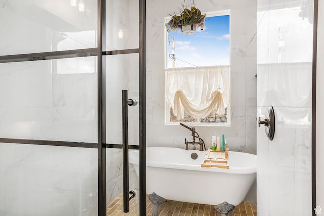 full bathroom with a soaking tub and tile walls