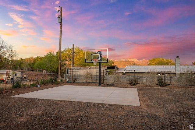 view of basketball court with fence and basketball hoop