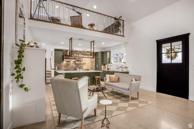 living room featuring light speckled floor, a high ceiling, recessed lighting, and a healthy amount of sunlight