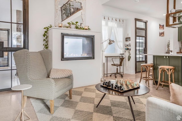 sitting room featuring light speckled floor