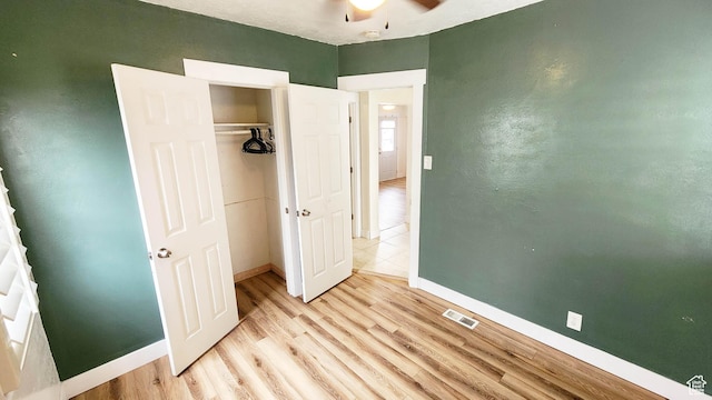unfurnished bedroom featuring a closet, baseboards, light wood finished floors, and visible vents
