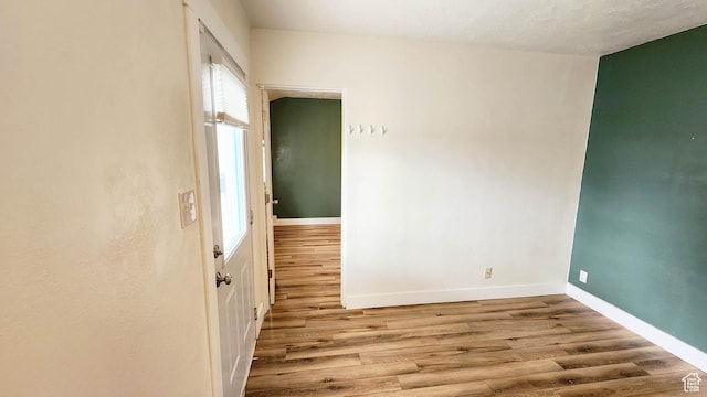 empty room with baseboards and wood finished floors