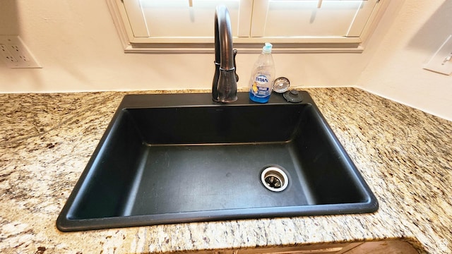 details featuring light stone countertops and a sink